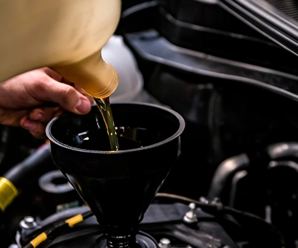 technician filling a car with oil