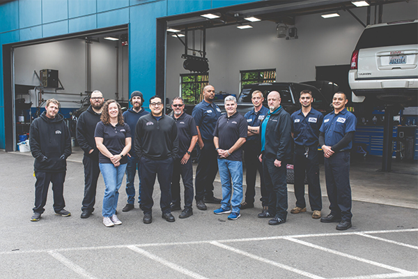 Group of people standing in front of an auto repair shop