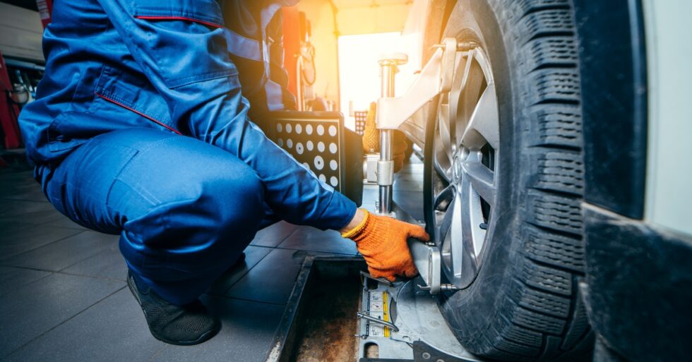 Technician mounting alignment machine to wheel