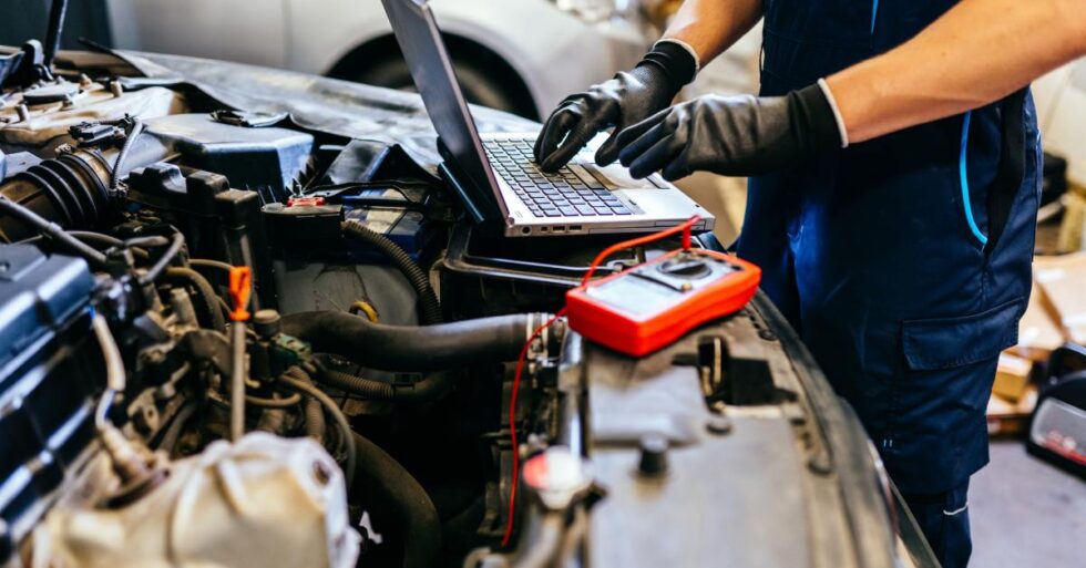 Technician checking vehicle condition on laptop